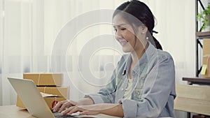 Beautiful smart Asian young entrepreneur business woman owner of SME online checking product on stock and save to computer working