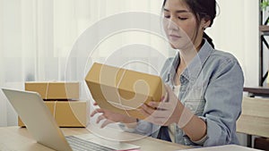 Beautiful smart Asian young entrepreneur business woman owner of SME online checking product on stock and save to computer working