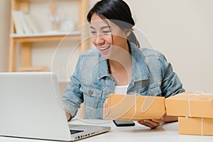 Beautiful smart Asian young entrepreneur business woman owner of SME online checking product on stock and save to computer working