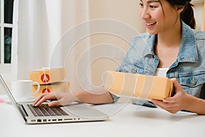 Beautiful smart Asian young entrepreneur business woman owner of SME online checking product on stock and save to computer working