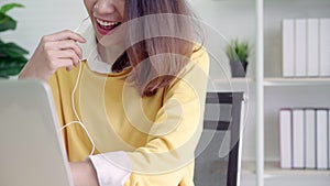 Beautiful smart business Asian woman in smart casual wear working on laptop and talking in a video conference on line.