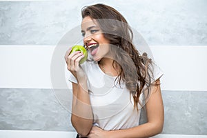 Beautiful smile with white strong teeth snow-white smile holding green apple