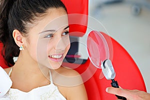 Beautiful smile with white teeth. A dentist examines the oral cavity of a young beautiful girl