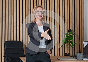 Beautiful smiling adult business woman giving hand for handshake