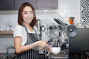 A beautiful smiling Asian woman owns a small coffee shop. photo