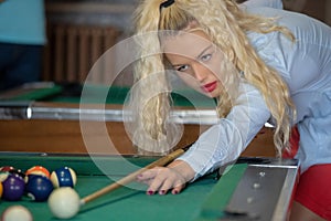 Beautiful smiling blonde women playing billiards