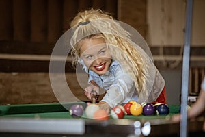 Beautiful smiling blonde women playing billiards