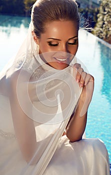 Beautiful smiling bride with blond hair in elegant wedding dress