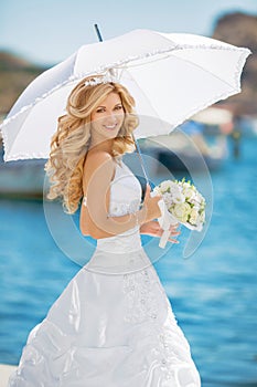 Beautiful smiling bride girl in wedding dress with white umbrell