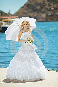 Beautiful smiling bride girl in wedding dress with white umbrell