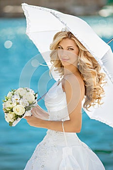 Beautiful smiling bride girl in wedding dress with white umbrell