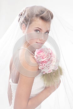 Beautiful smiling bride in the veil with bouquet