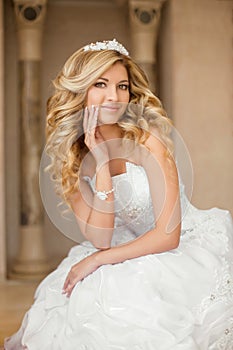 Beautiful smiling bride woman with long curly hair posing in wed