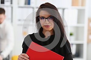 Beautiful smiling brunette woman hold in arms red binder