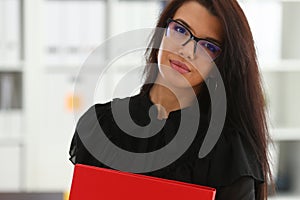 Beautiful smiling brunette woman hold in arms red binder