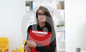 Beautiful smiling brunette woman hold in arms red binder