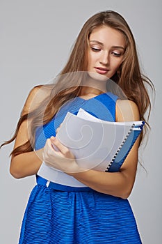 Beautiful smiling business woman, with documents, on a gray back