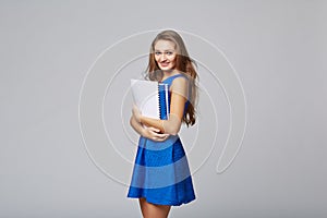 Beautiful smiling business woman, with documents, on a gray back