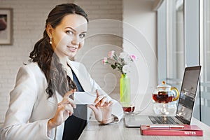 Beautiful smiling businesswoman and showing business card in her hands