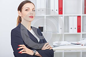 Beautiful smiling businesswoman sitting with arms across.