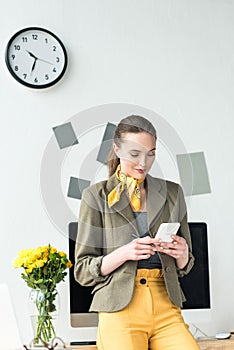 beautiful smiling businesswoman using smartphone