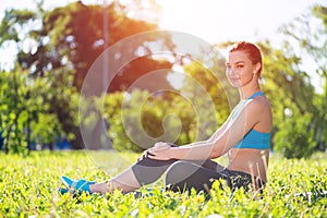 Beautiful smiling girl in activewear relax in park