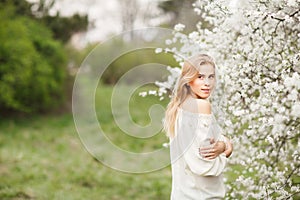 Beautiful smiling girl in blossom garden on a spring day