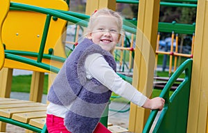 Beautiful smiling cute girl on a playground