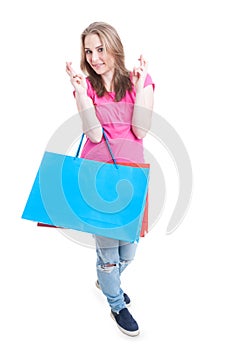 Beautiful smiling girl holding paper bags and wishing good luck