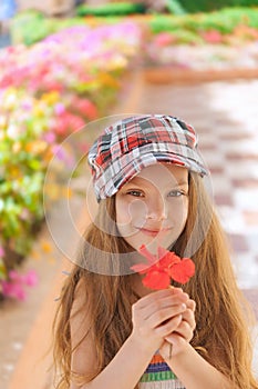 Beautiful smiling girl holding red flower