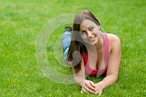 Beautiful smiling girl lying in the grass