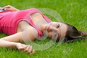 Beautiful smiling girl lying on the grass