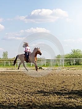 Beautiful smiling girl riding a purebred horse