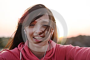 Beautiful Smiling Girl Runner Take Selfie from Hands with Phone Outdoor on Summer Evening. Healthy Lifestyle Concept