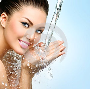 Beautiful smiling girl under splash of water