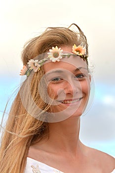 Beautiful smiling girl wearing a flower wreath