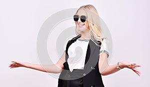 Beautiful smiling joyful girl meets acquaintances and friends. Fashionable blonde in sunglasses in the studio. Pretty young woman