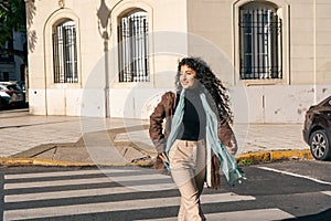 Beautiful smiling latin woman crossing the street