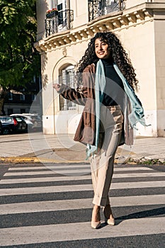 Beautiful smiling latin woman crossing the street