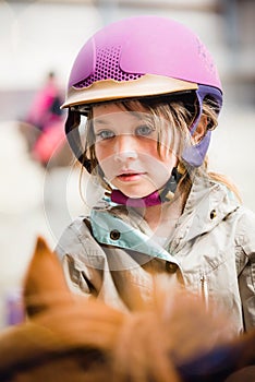 beautiful smiling little girl on her pony taking a riding lesson