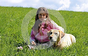 Beautiful smiling little girl with labrador dog