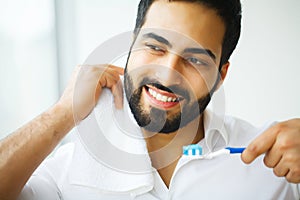 Beautiful Smiling Man Brushing Healthy White Teeth With Brush. H