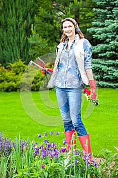 Beautiful smiling middle-aged woman in a flower garden