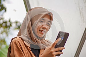 beautiful smiling Muslim woman playing social media