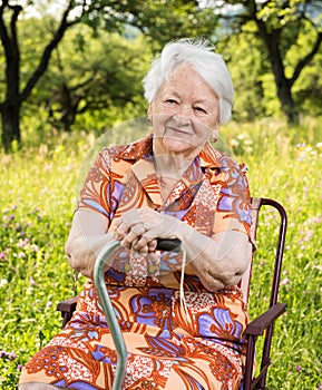 Beautiful smiling old woman sitting in the chair