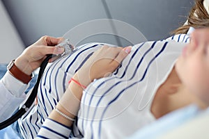 Beautiful smiling pregnant woman with the doctor at hospital