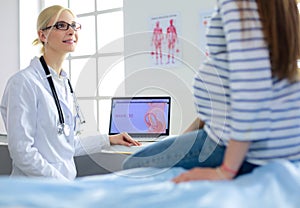 Beautiful smiling pregnant woman with the doctor at hospital