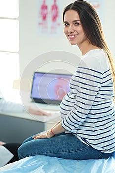 Beautiful smiling pregnant woman with the doctor at hospital