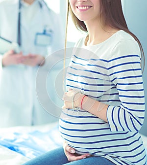 Beautiful smiling pregnant woman with the doctor at hospital