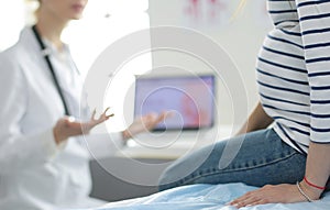 Beautiful smiling pregnant woman with the doctor at hospital